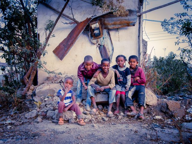 Kids sitting in front of the ruins of a house in Sengatera, Addis Ababa
