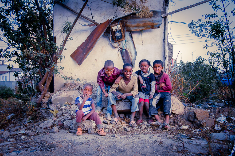 Kids sitting in front of the ruins of a house in Sengatera, Addis Ababa